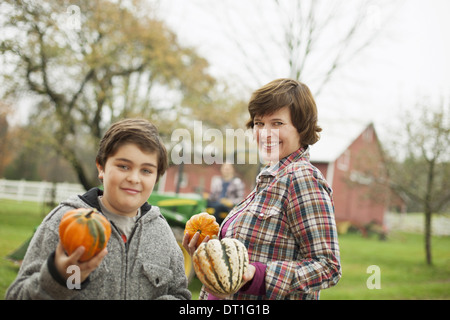 Due persone una donna e un bambino su di una azienda agricola biologica che trasportano ortaggi raccolti spremute e zucche agricoltura biologica