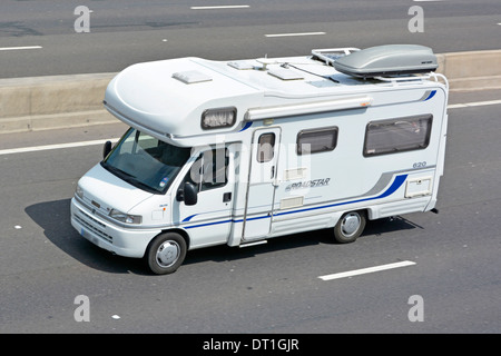 Camper Van con scatola del tetto viaggiando lungo l'autostrada (oscurate targa) Foto Stock