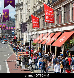 Affollate folle di persone da sopra Hamleys negozio di giocattoli business Regent Street risciò conducenti in corsia autobus per turisti e acquirenti Londra Regno Unito Foto Stock