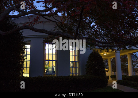 Il Presidente Usa Barack Obama parla con il capo del personale Denis McDonough visibile attraverso una finestra nell'Ufficio Ovale della Casa Bianca Novembre 18, 2013 a Washington, DC. Foto Stock