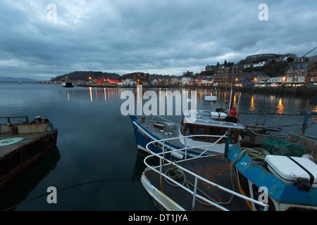 Città di Oban, Scozia. Vista del tramonto di Oban del porto con la spianata di George Street e McCaig's Tower in background. Foto Stock