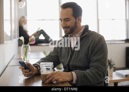 Matura in un momento di relax a casa con il computer portatile e l'E-READER Foto Stock