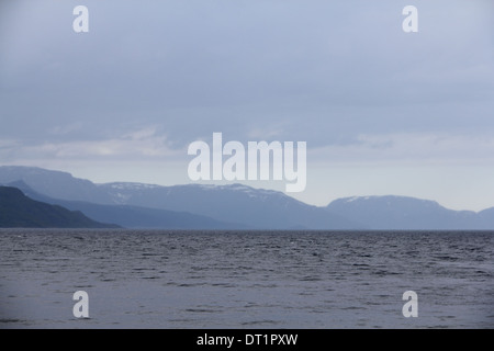 Blu scuro nuvole temporalesche oltre le rocce costiere, Norvegia Foto Stock