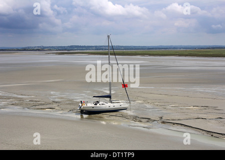 Yacht a filamento vicino all'abbazia di Mont Saint Michel attende di marea, a salpare. La Normandia, Francia Foto Stock