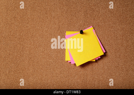 Mazzetto di vuoto sticky notes sulla bacheca di sughero Foto Stock