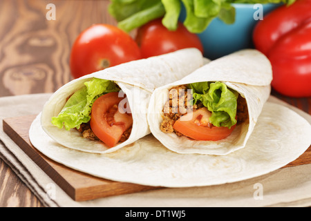 Burrito di manzo con pomodoro e foglia di insalata sul vecchio tavolo in legno in stile rustico Foto Stock