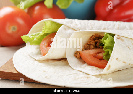 Burrito di manzo con pomodoro e foglia di insalata sul vecchio tavolo in legno in stile rustico Foto Stock