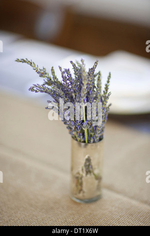 Un piccolo vaso con freschi fiori di lavanda su un tavolo Foto Stock