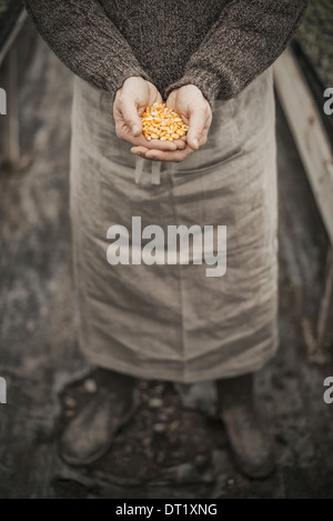 La molla di piantare un uomo con una manciata di semi di piante nelle sue mani a tazza Foto Stock