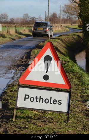 La trazione a quattro ruote motrici veicolo transitante cartello segnaletico di buche sulla strada di campagna Yorkshire Regno Unito Foto Stock