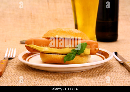 Il tedesco la salsiccia con bun, senape e birra, close up Foto Stock