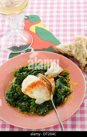 Uova sode con paprika affumicato su letto di spinaci Foto Stock