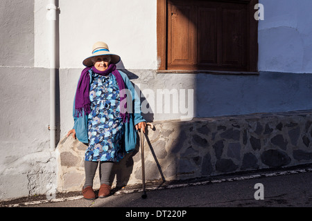 Ritratto di signora anziana indossando cappello di paglia, viola sciarpa e blue coat in Arguayo, Tenerife, Isole Canarie, Spagna. Foto Stock