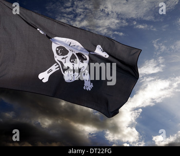 Jolly Roger (bandiera pirata) contro le nuvole di tempesta Foto Stock