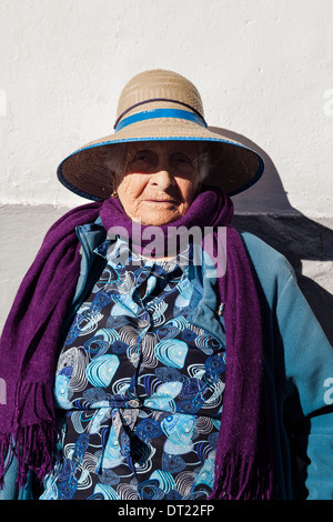 Ritratto di signora anziana indossando cappello di paglia, viola sciarpa e blue coat in Arguayo, Tenerife, Isole Canarie, Spagna. Foto Stock