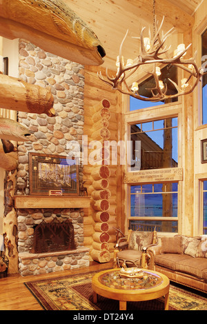 La grande sala in un moderno log cabin, con decorazioni rustiche e mobili. Foto Stock