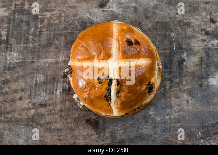 Una pasqua hot cross bun sul vecchio tavolo in legno Foto Stock