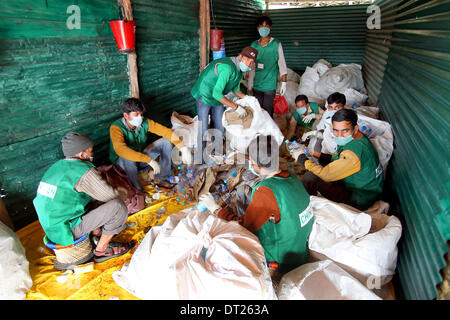 New Delhi, India. 6 febbraio, 2014. I bambini di strada del progetto welfare "Chintan' riciclare le bottiglie dell'acqua vuote in New Delhi, India, 6 febbraio 2014. Chintan è un Indiano organizzazione di volontari che cooperano con locali in materia di riciclaggio e i garbage collector per ridurre la quantità di rifiuti prodotta dalla società di consumo e di preservare l'ambiente. Il Ministro tedesco per la Cooperazione Economica e lo sviluppo, Gerd Mueller, fa parte della delegazione ufficiale del Presidente tedesco Gauck che sono attualmente su un 6 Giorno in visita in India. Foto: Wolfgang Kumm/dpa/Alamy Live News Foto Stock