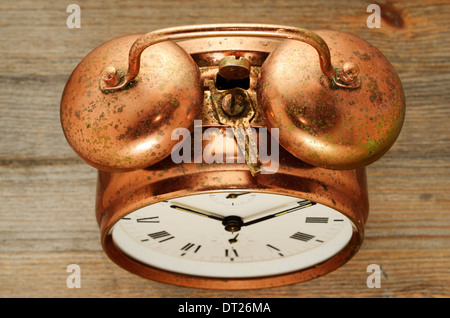 Un vecchio stile vintage rame sveglia su sfondo di legno Foto Stock
