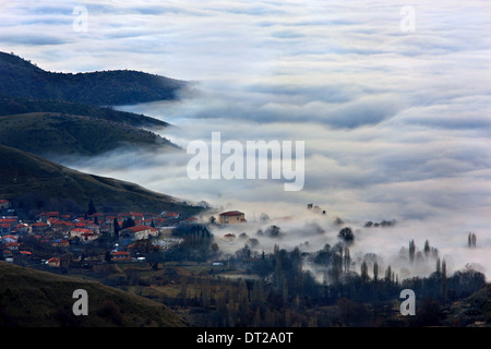 Agios Ghermanos villaggio in un 'sea' di nuvole, laghi Prespes (sotto le nuvole), Florina, Macedonia, Grecia. Foto Stock