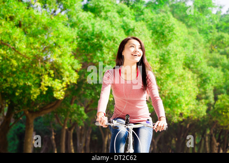 Pretty asian giovane donna bicicletta equitazione nel Parco Foto Stock