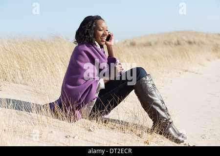 Stati Uniti d'America, Illinois, Waukegan, Ritratto di giovane donna seduta in erba e utilizzando il telefono cellulare Foto Stock