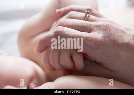 Madre mentre tiene il suo bambino di mia figlia (6-11 mesi) a mano Foto Stock