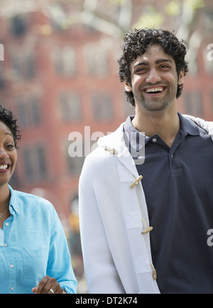 Il parcheggio di un uomo e di una donna a fianco a fianco di sorridere Foto Stock