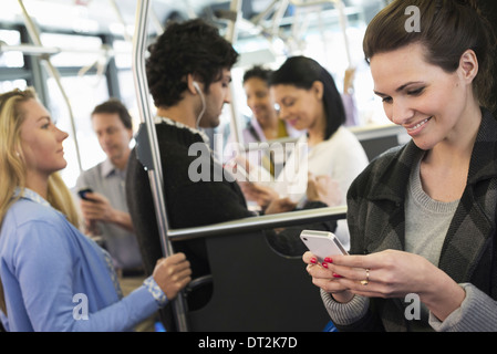 La gente gli uomini e le donne su un autobus di città Foto Stock