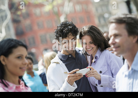Un giovane al centro guardando a un telefono cellulare Foto Stock