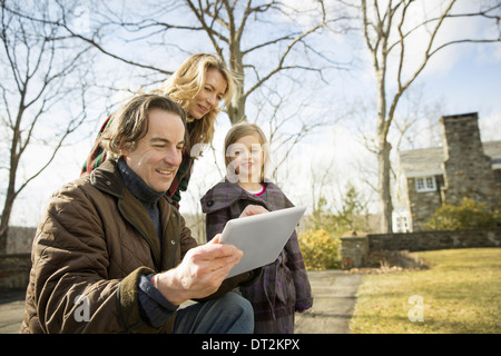 Un agriturismo biologico in inverno in Cold Spring nello Stato di New York un uomo con una tavoletta digitale nelle mani di una donna e di un bambino Foto Stock