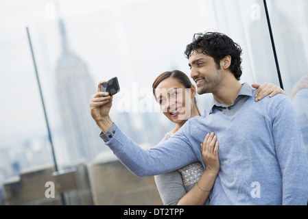 Vista sulla città coppia giovane scattare fotografie con un telefono cellulare Foto Stock