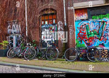 Bicicletta e coloratissimo graffito street scene in Amsterdam, Olanda Foto Stock