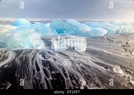 Iceberg e onde sulla spiaggia di Jokulsarlon, regione polare, Sud Islanda Foto Stock