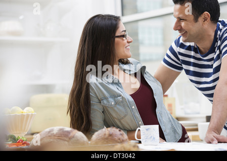 In un ufficio o un interno dell appartamento a New York City due persone una coppia accanto al bar per la prima colazione Foto Stock