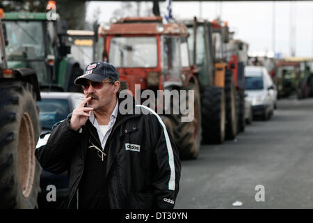 Nikaia, Larissa, Grecia. 7 febbraio 2014. Gli agricoltori cercano di bloccare l'autostrada tra Salonicco e Atene in Nikaia, circa 380 km a nord di Atene. Protesta degli agricoltori greci, che chiedono agevolazioni fiscali e di altri benefici, hanno rifiutato un offerta da parte del governo greco dopo un febbraio 6 sale riunioni e ci hanno detto che non avrebbe relent e mantenere i loro trattori posizionati in corrispondenza di punti chiave sulle strade principali in tutta la Grecia, che hanno continuamente minacciato di bloccare a meno che essi non siano di ottenere tutto ciò che vogliono. Nikaia, Grecia nel febbraio 7, 2014. Credito: Konstantinos Tsakalidis/Alamy Live News Foto Stock