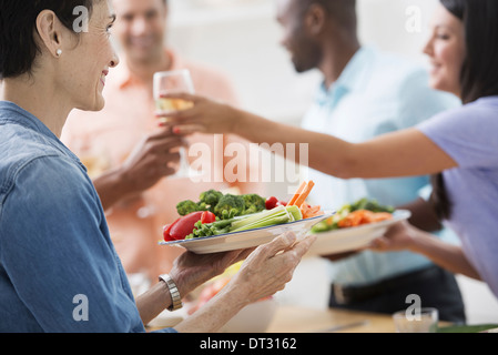 Un pranzo di lavoro a buffet di insalate una donna tenendo fuori un bicchiere di vino e un piatto di cibo