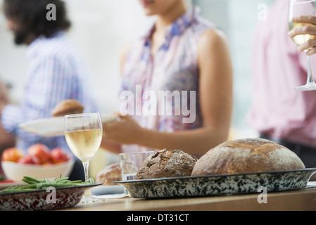 Un piano aperto in ufficio per un pranzo di lavoro a buffet di insalate di età mista e le etnie riuniti insieme Foto Stock