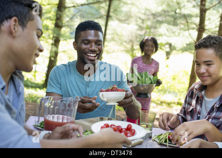 I genitori e i bambini ad aiutare se stessi per la frutta e la verdura fresca Foto Stock