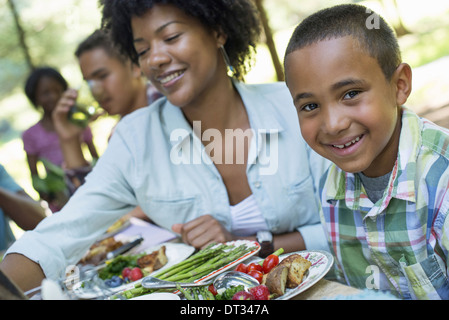 I genitori e i bambini ad aiutare se stessi per la frutta e la verdura fresca Foto Stock