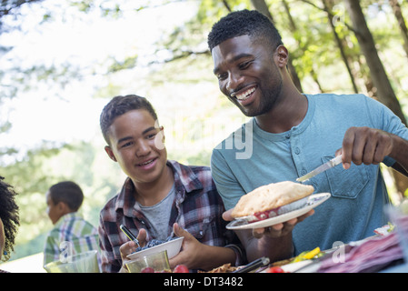 I genitori e i bambini ad aiutare se stessi per la frutta e la verdura fresca Foto Stock