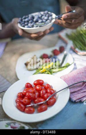 I genitori e i bambini ad aiutare se stessi per la frutta e la verdura fresca Foto Stock