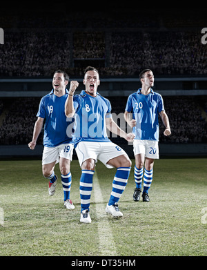 I giocatori di calcio a fare il tifo per il campo Foto Stock