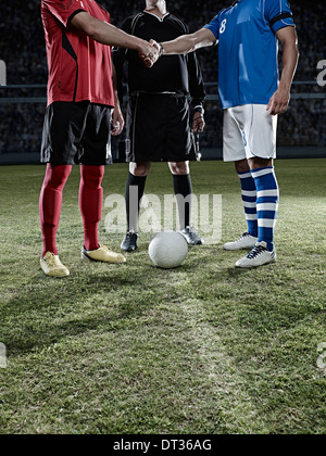 I giocatori di calcio si stringono la mano sul campo Foto Stock