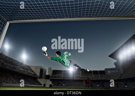Goalie jumping per la sfera nel calcio net Foto Stock