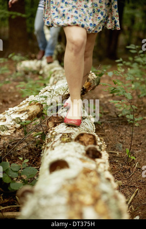 Due persone a piedi lungo un albero caduto tronco Foto Stock