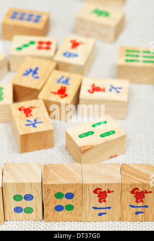 Piastrelle di legno closeup nel gioco mahjong durung giocando sulla tabella di tessili Foto Stock