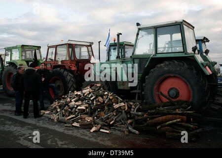 Nikaia, Larissa, Grecia. 7 febbraio 2014. Gli agricoltori cercano di bloccare l'autostrada tra Salonicco e Atene in Nikaia, circa 380 km a nord di Atene. Protesta degli agricoltori greci, che chiedono agevolazioni fiscali e di altri benefici, hanno rifiutato un offerta da parte del governo greco dopo un febbraio 6 sale riunioni e ci hanno detto che non avrebbe relent e mantenere i loro trattori posizionati in corrispondenza di punti chiave sulle strade principali in tutta la Grecia, che hanno continuamente minacciato di bloccare a meno che essi non siano di ottenere tutto ciò che vogliono. Nikaia, Grecia nel febbraio 7, 2014. Credito: Konstantinos Tsakalidis/Alamy Live News Foto Stock