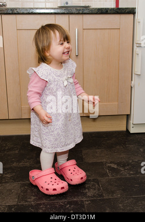 18 mese bambina indossa madre scarpe rende inabile al lavoro. Foto Stock
