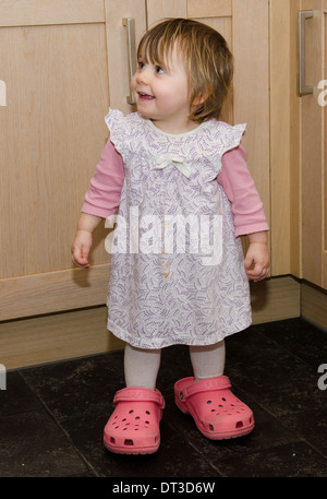 18 mese bambina indossa madre scarpe rende inabile al lavoro. Foto Stock